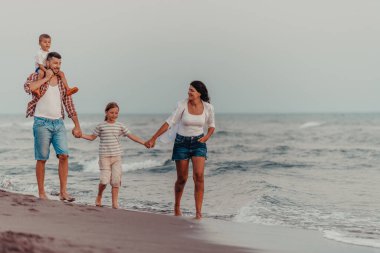 Aile toplantıları ve gün batımında sahilde sosyalleşme. Aile kumlu sahil boyunca yürür. Seçici odaklanma. Yüksek kalite fotoğraf