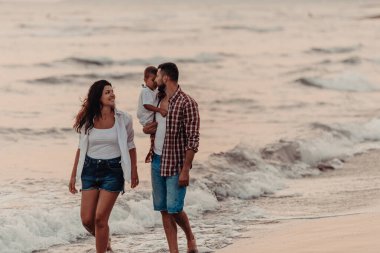 Aile, oğluyla kumsalda yürürken tatilin tadını çıkarıyor. Seçici odaklanma. Yüksek kalite fotoğraf