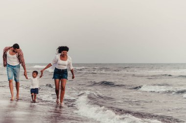 Aile, oğluyla kumsalda yürürken tatilin tadını çıkarıyor. Seçici odaklanma. Yüksek kalite fotoğraf