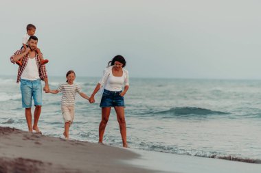 Aile toplantıları ve gün batımında sahilde sosyalleşme. Aile kumlu sahil boyunca yürür. Seçici odaklanma. Yüksek kalite fotoğraf