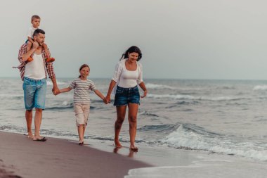 Aile toplantıları ve gün batımında sahilde sosyalleşme. Aile kumlu sahil boyunca yürür. Seçici odaklanma. Yüksek kalite fotoğraf