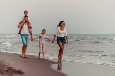 Aile toplantıları ve gün batımında sahilde sosyalleşme. Aile kumlu sahil boyunca yürür. Seçici odaklanma. Yüksek kalite fotoğraf
