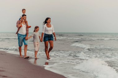 Aile toplantıları ve gün batımında sahilde sosyalleşme. Aile kumlu sahil boyunca yürür. Seçici odaklanma. Yüksek kalite fotoğraf