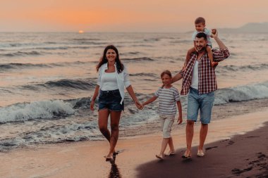 Aile toplantıları ve gün batımında sahilde sosyalleşme. Aile kumlu sahil boyunca yürür. Seçici odaklanma. Yüksek kalite fotoğraf