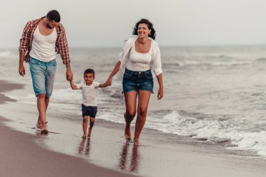 Aile, oğluyla kumsalda yürürken tatilin tadını çıkarıyor. Seçici odaklanma. Yüksek kalite fotoğraf