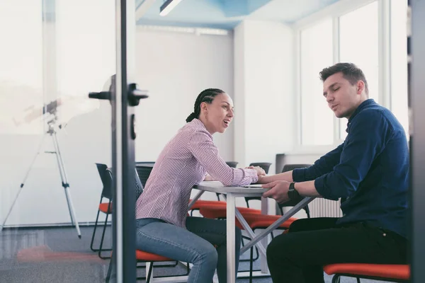 businesspeople, rivalry and people concept - businesswoman and businessman arm wrestling during corporate meeting in modern bright open space coworking startup business office. High quality photo