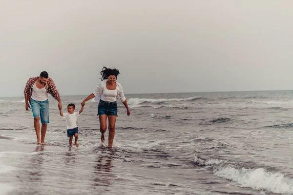 当他们和儿子在沙滩上散步时 一家人都很享受假期 有选择的重点 高质量的照片 — 图库照片