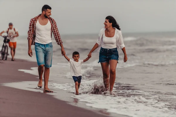 当他们和儿子在沙滩上散步时 一家人都很享受假期 有选择的重点 高质量的照片 — 图库照片