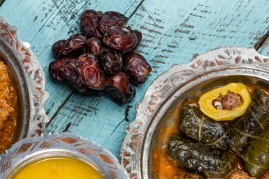 Bayram Mübarek Geleneksel Ramazan iftar yemeği. Ahşap mavi arka planda otantik kırsal tabaklarda çeşitli lezzetli yemekler. Türk yemeği kebap, pide, sarma, klepe, sogan dolma. Yüksek kalite