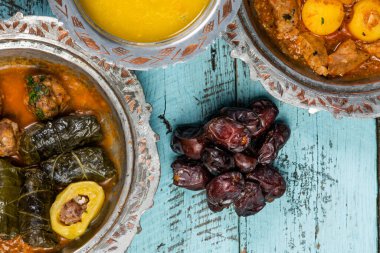 Bayram Mübarek Geleneksel Ramazan iftar yemeği. Ahşap mavi arka planda otantik kırsal tabaklarda çeşitli lezzetli yemekler. Türk yemeği kebap, pide, sarma, klepe, sogan dolma. Yüksek kalite