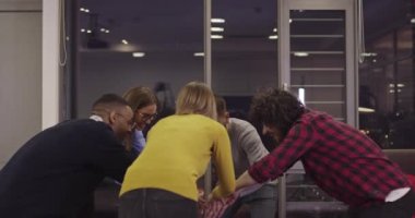 Coşkulu, çoklu etnik çeşitliliğe sahip genç iş adamları iş dünyasındaki ortak başarılarını ya da zaferlerini kutlarken eğleniyor. Gülümseyen çok ırklı çalışanlar iyi sonuçlar aldıkları için heyecanlılar. Takım çalışması.