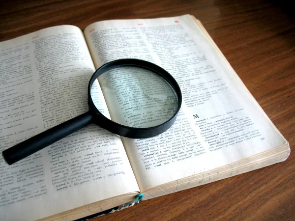 Book and magnifying glass — Stock Photo, Image