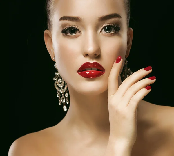 Сексуальная красавица с красными губами и ногтями. Роскошная женщина, ювелирные серьги. Мода Брюнетка портрет изолирован на черном фоне . — стоковое фото
