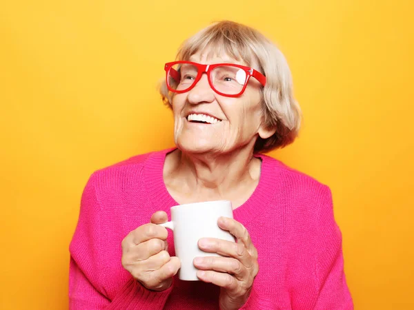 Stara Podekscytowana Pani Uśmiechnięta Trzymająca Filiżankę Kawy Herbatę Napój Żółtym — Zdjęcie stockowe