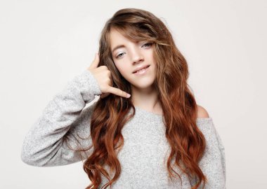 İşin gülümseyen kız telefon hareketi ile el ve parmak telefonda konuşuyor gibi. Kavramları iletişim. Yakın çekim.