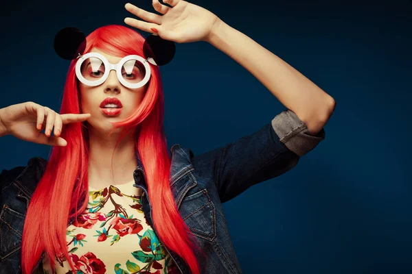 Moda ragazza con i capelli rosa e grandi occhiali da sole su sfondo blu — Foto Stock