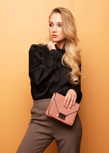Young Beautiful Blond Woman Black Blouse Brown Pants Holds Pink — Stock Photo, Image