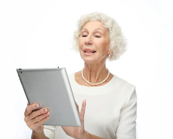 Lifestyle, technology and old people concept: Happy mature woman using a tablet over white background — Stock Photo, Image