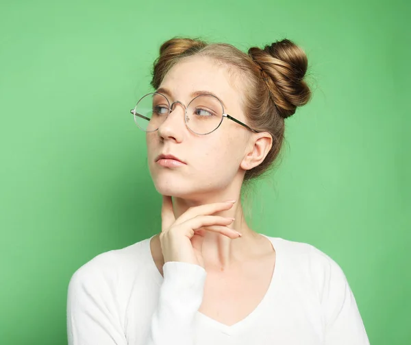 Hermosa joven rubia vistiendo ropa casual y gafas sobre fondo verde — Foto de Stock
