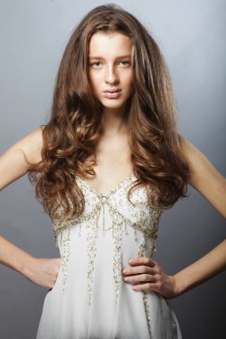 Uzun dalgalı ve parlak saçlı güzel bir kadın. Kıvırcık saçlı, beyaz elbiseli sarışın kadın..
