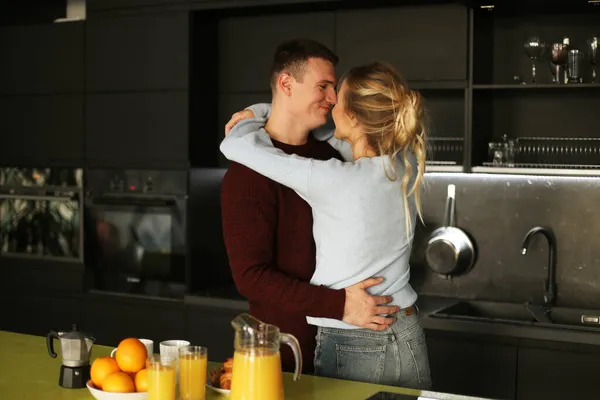 可爱的年轻夫妇站在家里的厨房里拥抱 — 图库照片