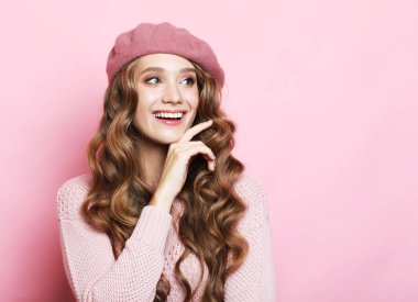 Profil yan görüntüsü portresi. Güzel görünümlü, çekici, sevimli, sevimli, neşeli, neşeli, neşeli, dalgalı saçlı, kolları katlanmış, pembe pastel renkli arka plan üzerine izole bir kadın.