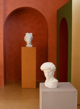 Kahverengi tonlarda modern iç mimari, kafa heykeli. Antika. Kemerler ve küpler.