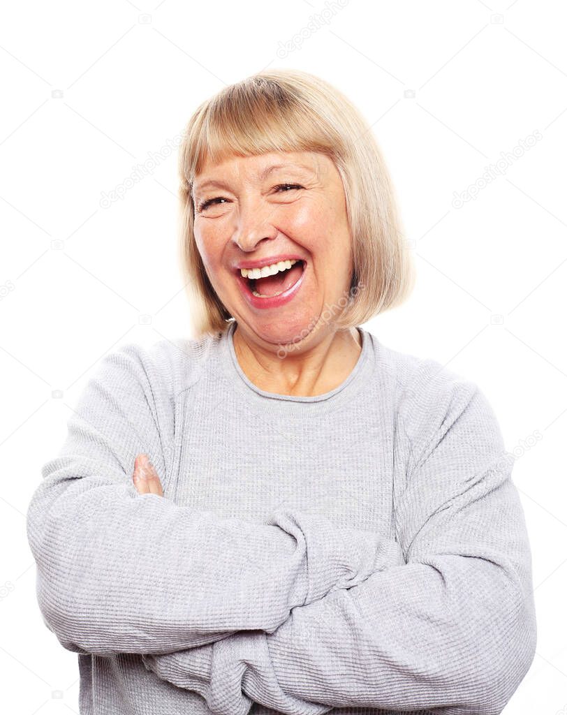 happy pensioner laughs joyfully, a woman is dressed in a blue jumper, experiences joyful emotions, photo on a gray background.
