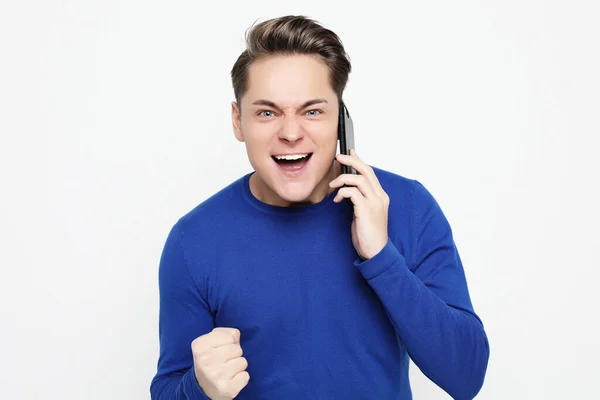 Jovem feliz na camisa gesticulando e sorrindo enquanto fala no celular — Fotografia de Stock