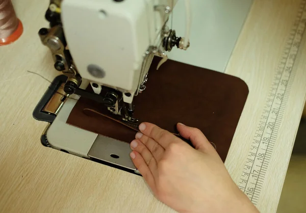 Junge Frau näht die Details einer Tasche an einer Nähmaschine — Stockfoto