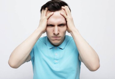 Stresli üzgün adam, beyaz gri arka planda izole edilmiş güçlü bir migrenden muzdarip.