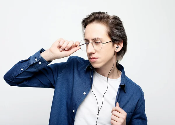 Jonge knappe man draagt bril luisteren naar muziek in hoofdtelefoon — Stockfoto