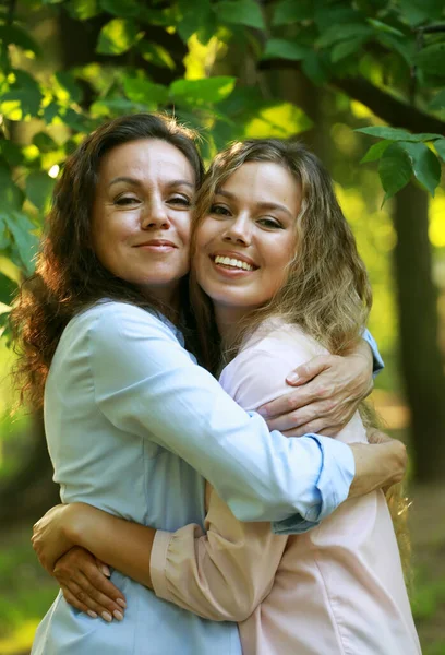 Η μαμά και η ενήλικη κόρη της αγκαλιάζονται σε ένα καλοκαιρινό πάρκο. — Φωτογραφία Αρχείου