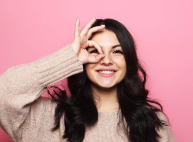 Yaşam tarzı, duygu ve insan konsepti: gülümseyen genç bir kadın mutlu bir şekilde el pençe divan duruyor.