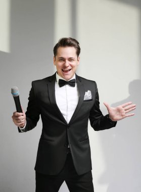 Takım elbise şarkı üzerinde mikrofon ile enerji genç adam.