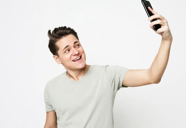 Retrato de homem branco bonito amigável tomando selfie ou videocalling com telefone celular — Fotografia de Stock