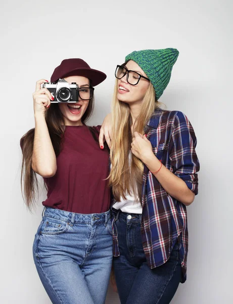 Jovens amigas felizes tirando algumas fotos witn câmera vintage, sobre fundo cinza — Fotografia de Stock