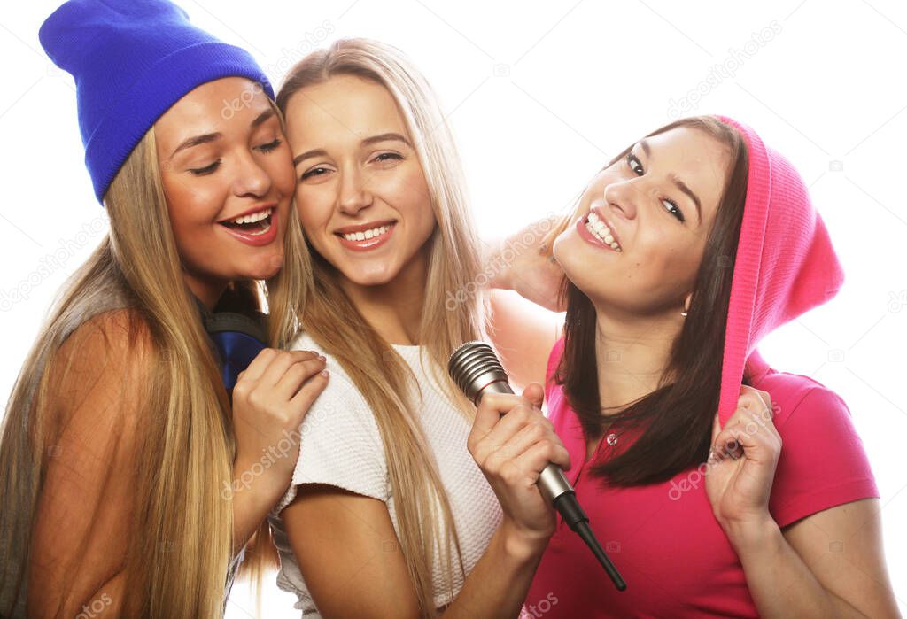 lifestyle, happiness, emotional and people concept: beauty hipster women with a microphone singing and having fun