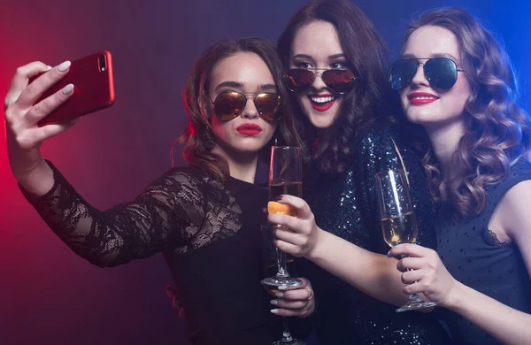 Nahaufnahme einer Gruppe lachender Frauen in schwarzen Kleidern, die Party machen und ein Selfie mit dem Smartphone machen — Stockfoto