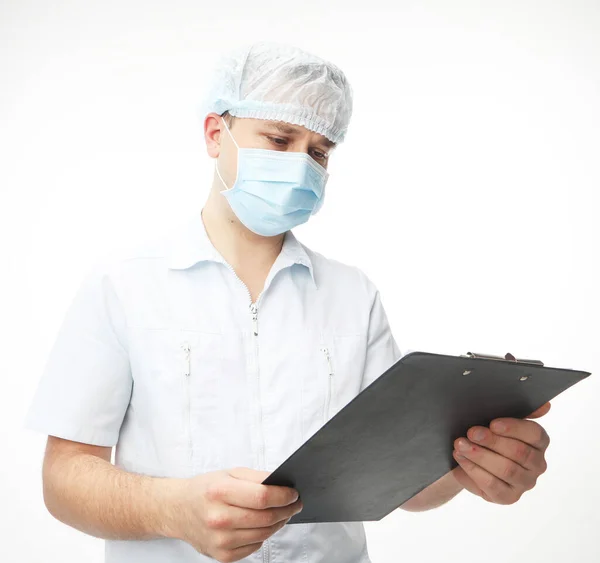 Joven médico masculino escribiendo en portapapeles sobre fondo blanco. —  Fotos de Stock