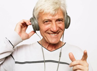 Gülümseme portresi. Kulaklıklı, beyaz saçlı yaşlı bir adam. Kapat.