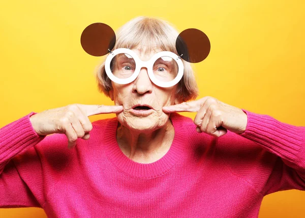 Starsza Kobieta Ubrana Różowy Sweter Duże Okulary Przeciwsłoneczne Robi Funky — Zdjęcie stockowe