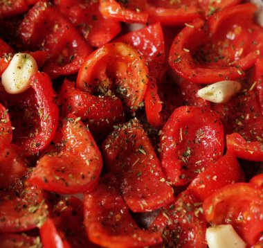 Domatesler fırın tepsisine konmuş, pişirmeye hazır. Sarımsaklı güneşte kurutulmuş domates. Gıda arkaplanı.