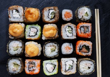 Suşi ve maki seti taş masada. Düz yatış, üst görünüm