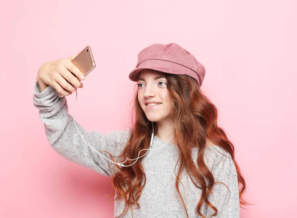 ピンクを背景に自撮りした帽子をかぶった陽気な女の子の肖像画 ライフスタイルと子供時代のコンセプト — ストック写真
