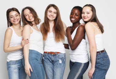 Beş büyüleyici çok ırklı kadının yakın plan portresi. Fotoğraf üstü açık gri arkaplan.