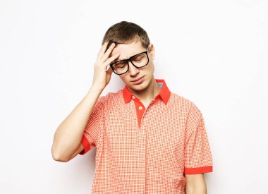 Başı ağrıdığı için eli başında olan yakışıklı genç bir adam..