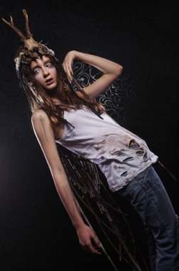 Parlak makyajlı, örgülü ve kafasında kafatası olan genç bir kadın.