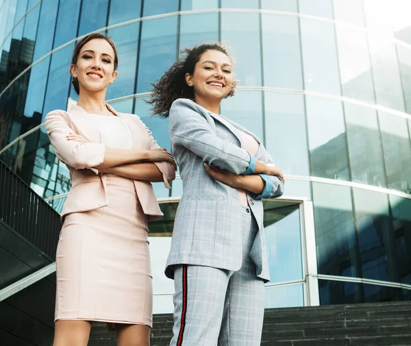 Business, people and lifestyle concept: two office workers standing together outdors near modern business building. — Stock Photo, Image