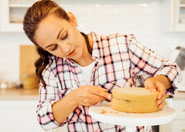 Güzel genç bayan pastaları bıçakla kesiyor..